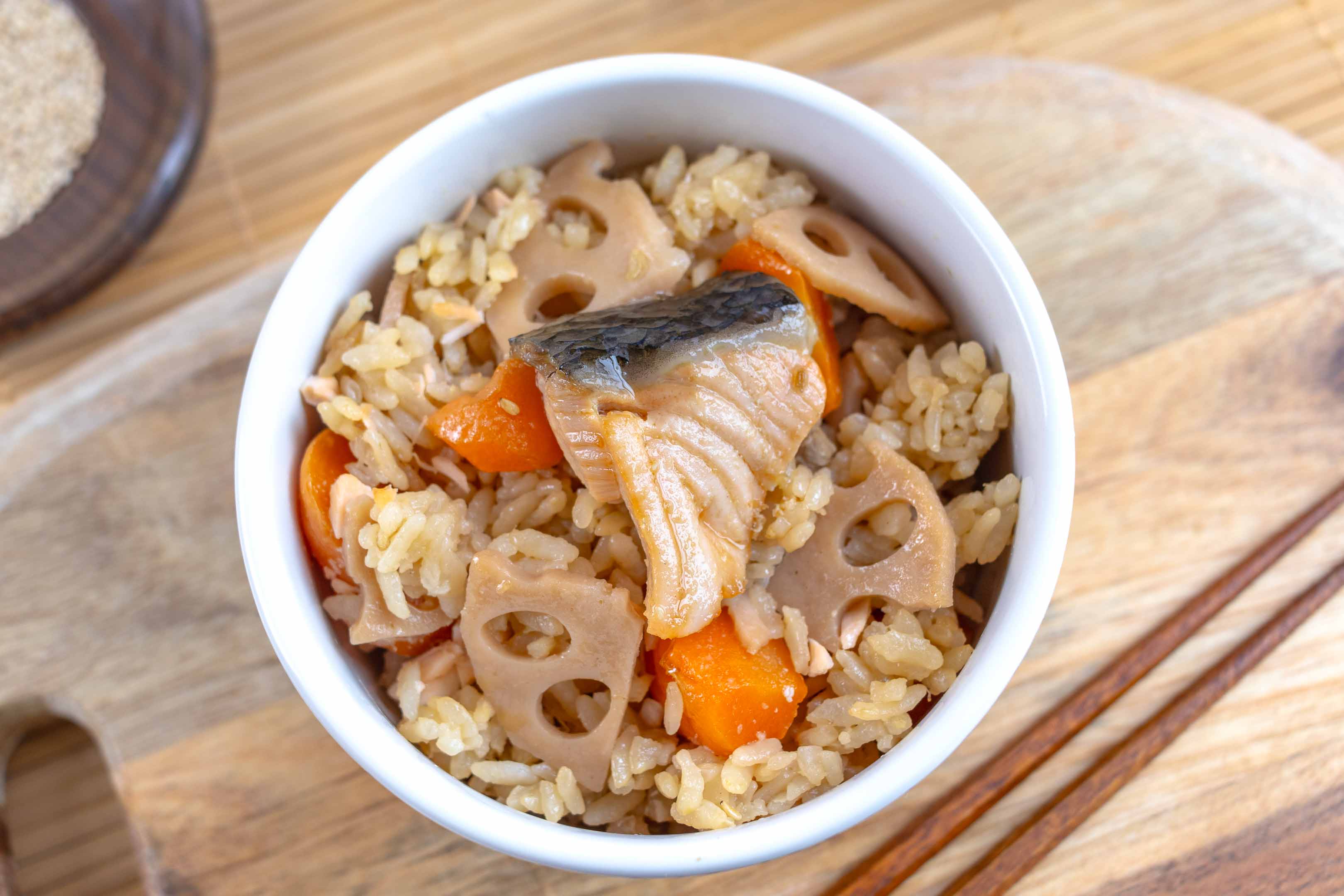 A bowl of Japanese mixed rice with carrot, salmon and lotus root.
