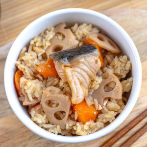 A bowl of Japanese mixed rice with carrot, salmon and lotus root.