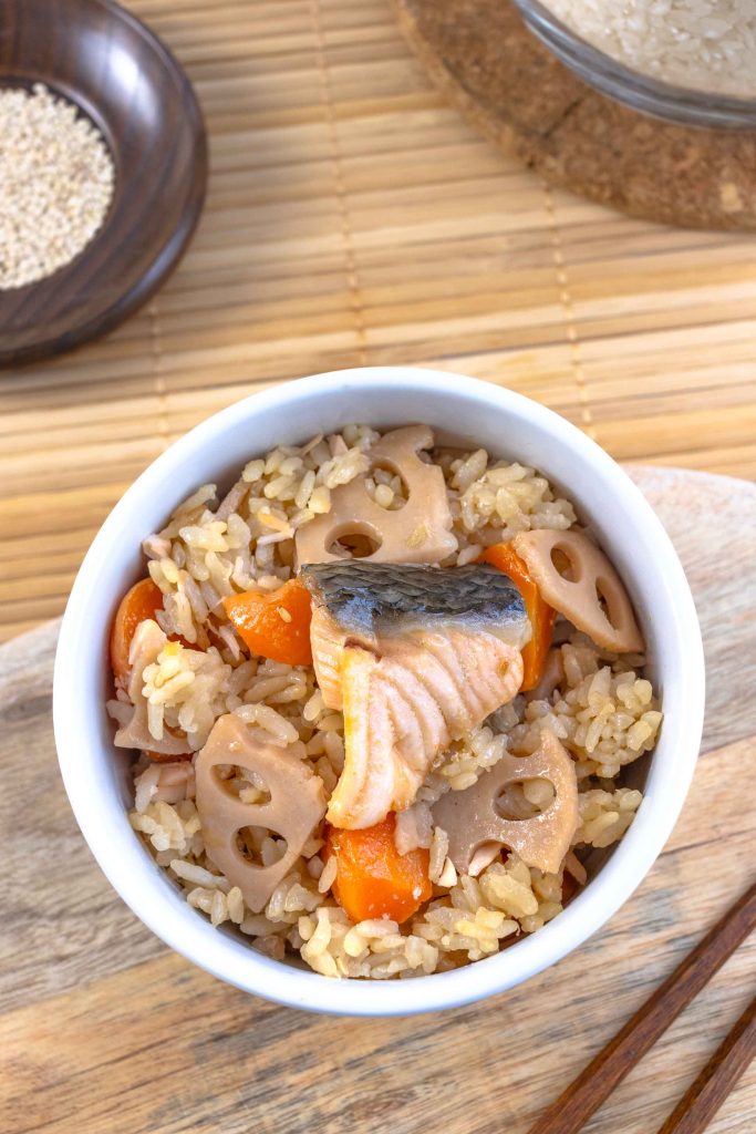A bowl of Japanese mixed rice with carrot, salmon and lotus root.