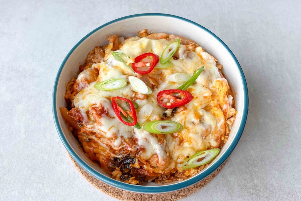A bowl of Kimchi Oyakodon with green onion and red chilli