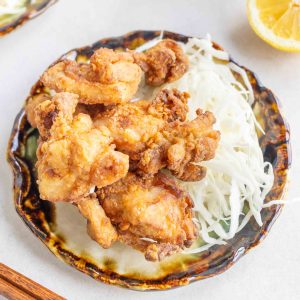 A small plate of Yuzu Kosho Fried Chicken with some shredded cabbage on the side.