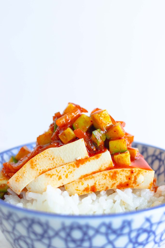 A bowl of cold kimchi tofu spooned over white rice.