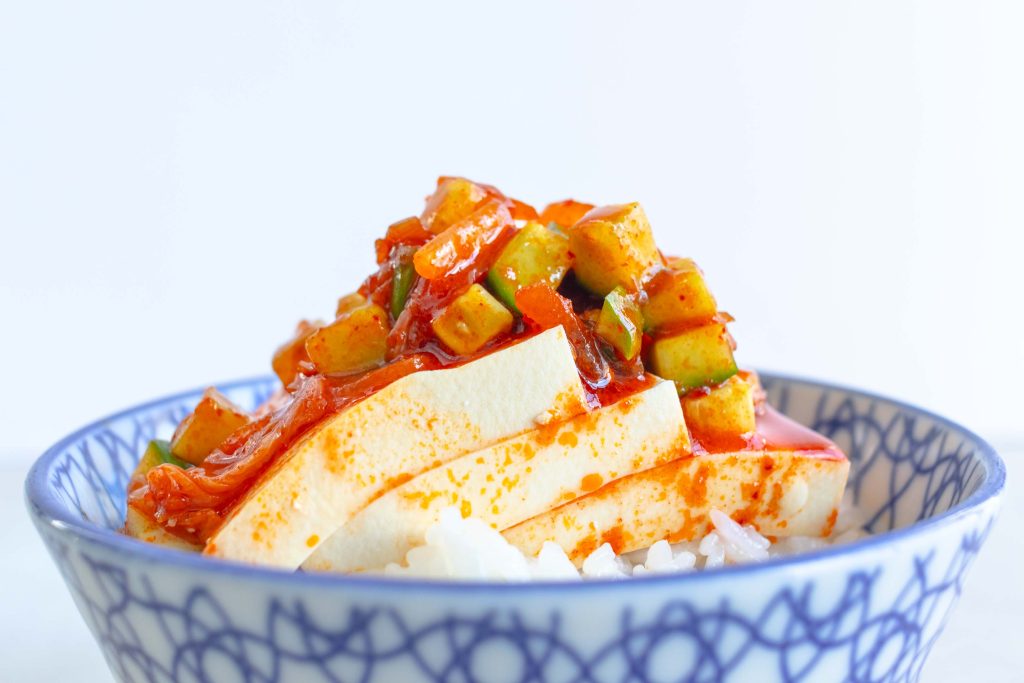 A bowl of cold kimchi tofu spooned over white rice.