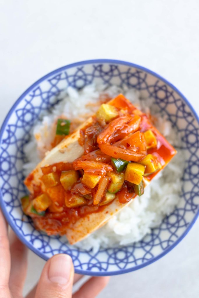A bowl of cold kimchi tofu spooned over white rice.