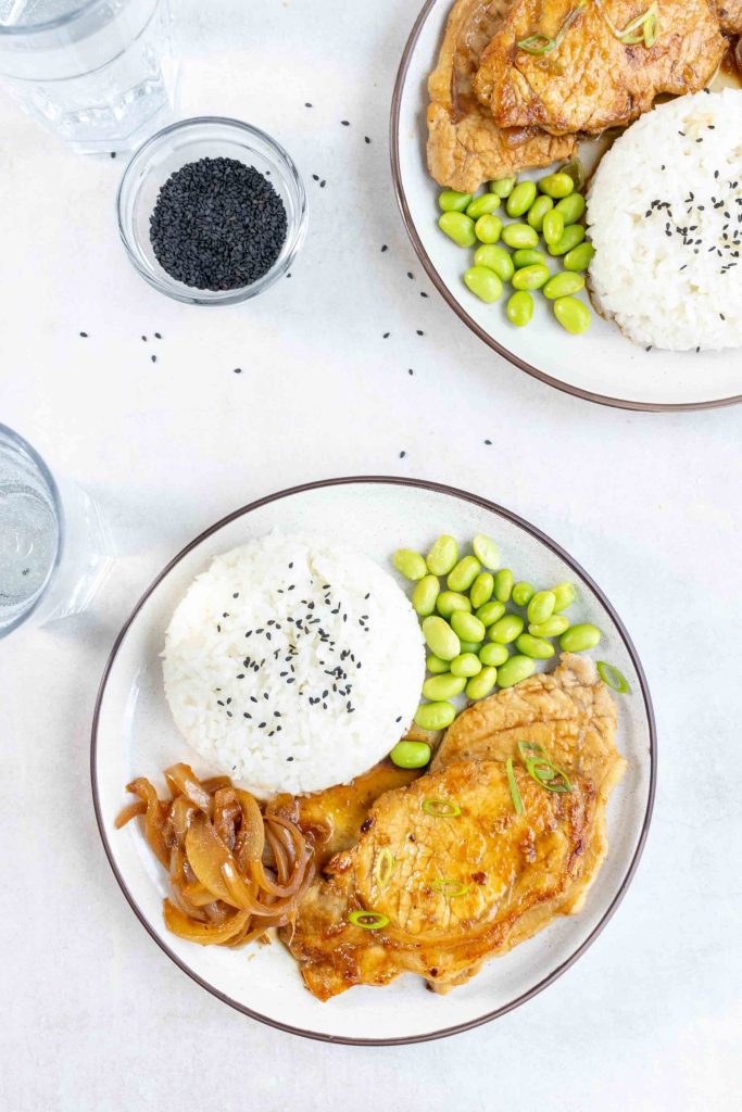A plate of Japanese Ginger Pork (Shogayaki) with a side of rice and edamame beans