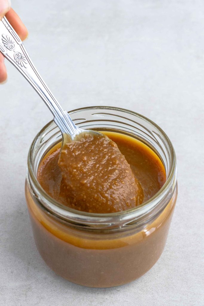 A jar of Miso marinade with a spoon scooping it out.