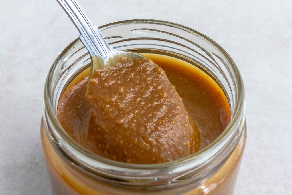A jar of Miso marinade with a spoon scooping it out.