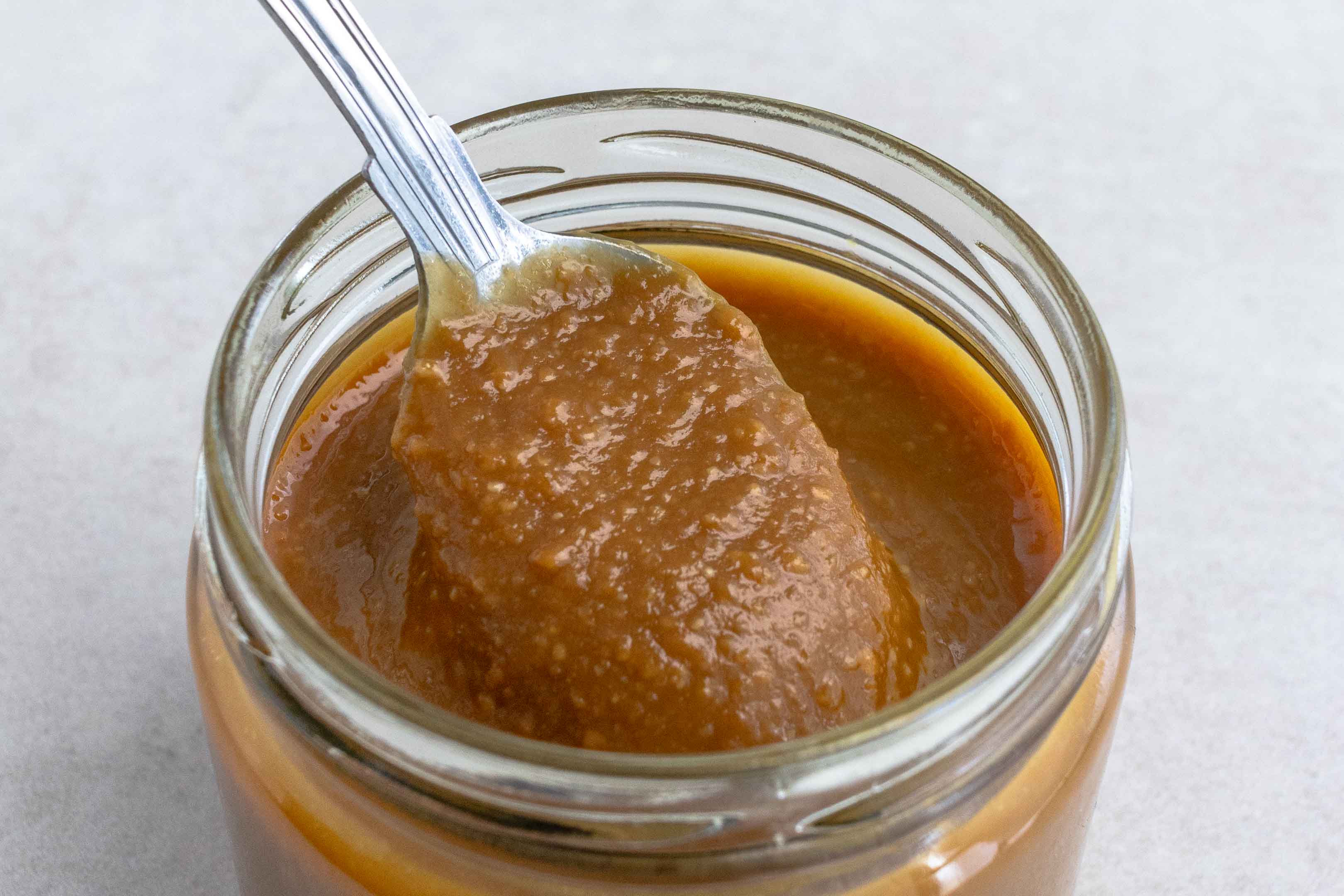 A jar of Miso marinade with a spoon scooping it out.