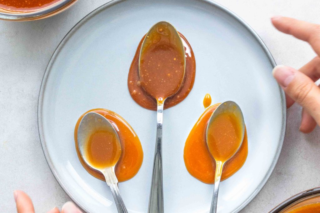 Three spoons on a plate covered with miso caramel.