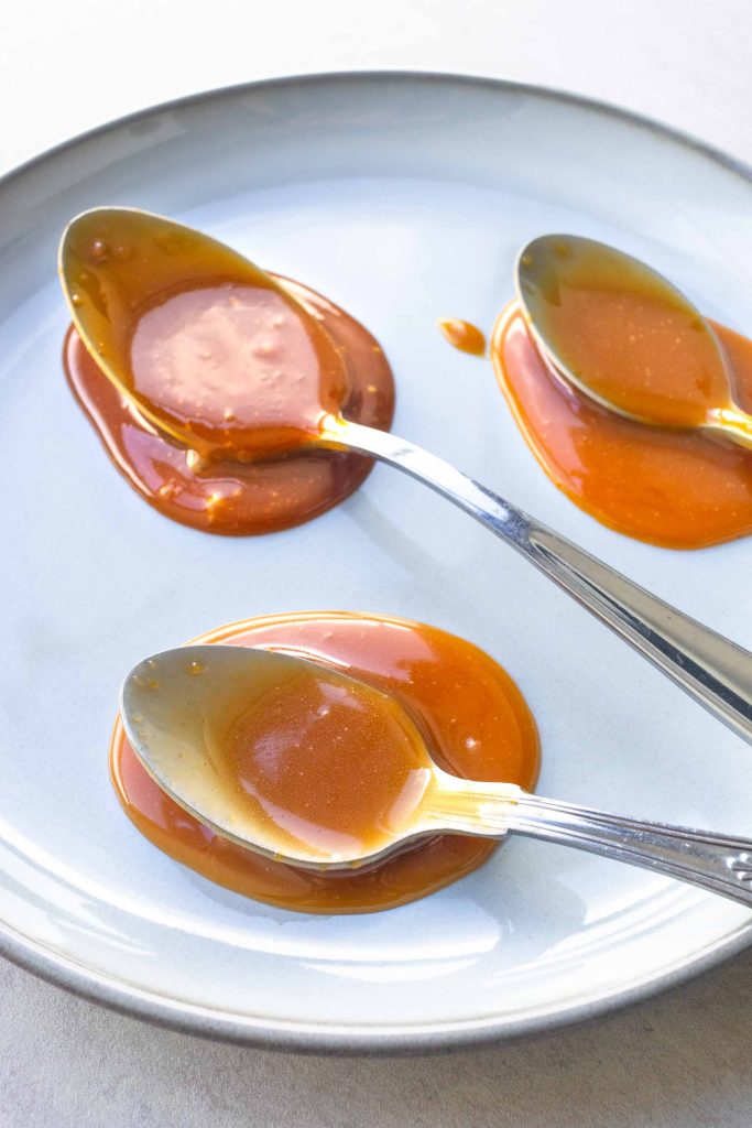 Three spoons on a plate covered with miso caramel.